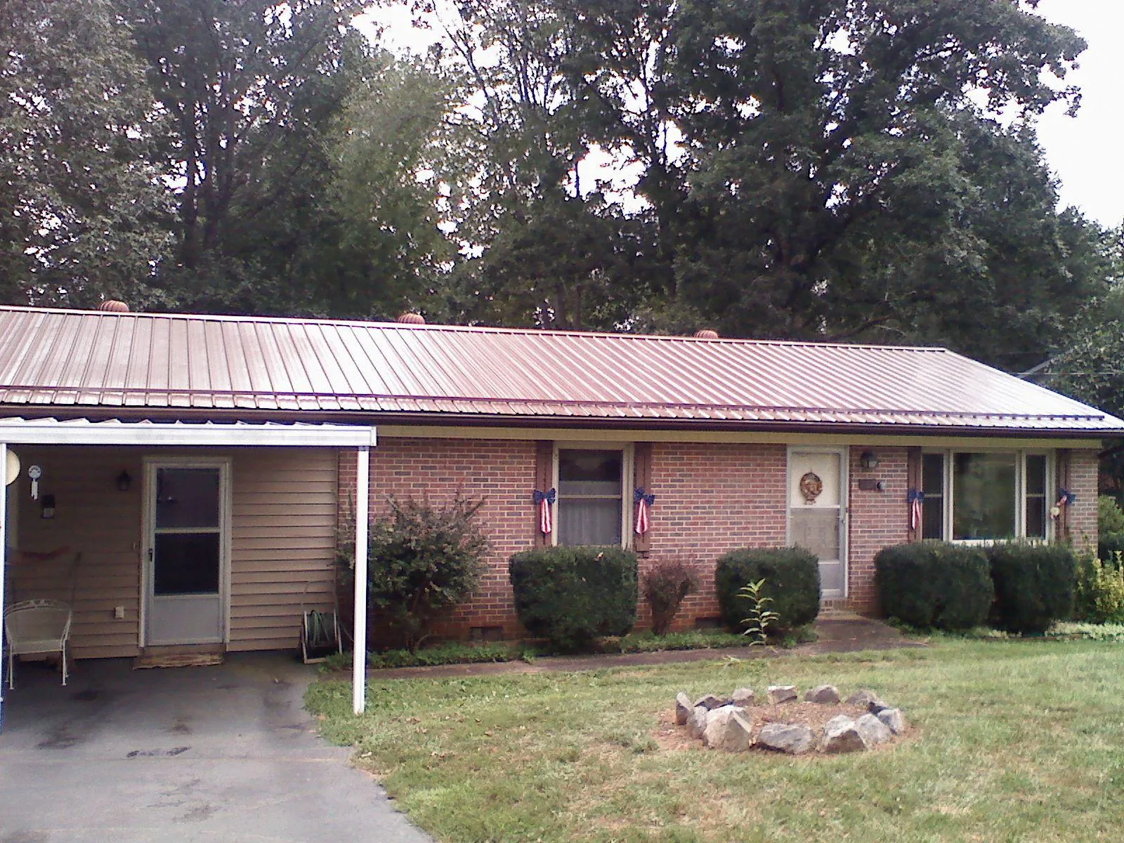 Bronze metal roof and carport on a brick ranch home — Roof Repair work by our crew in Ola