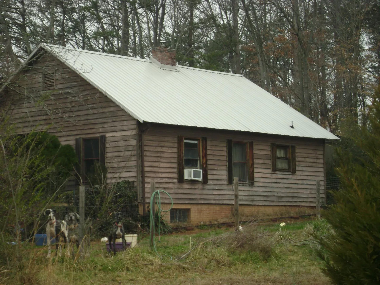 White metal roof on an old wood sided farmhouse, from a Metal Roof Installation job in Ola